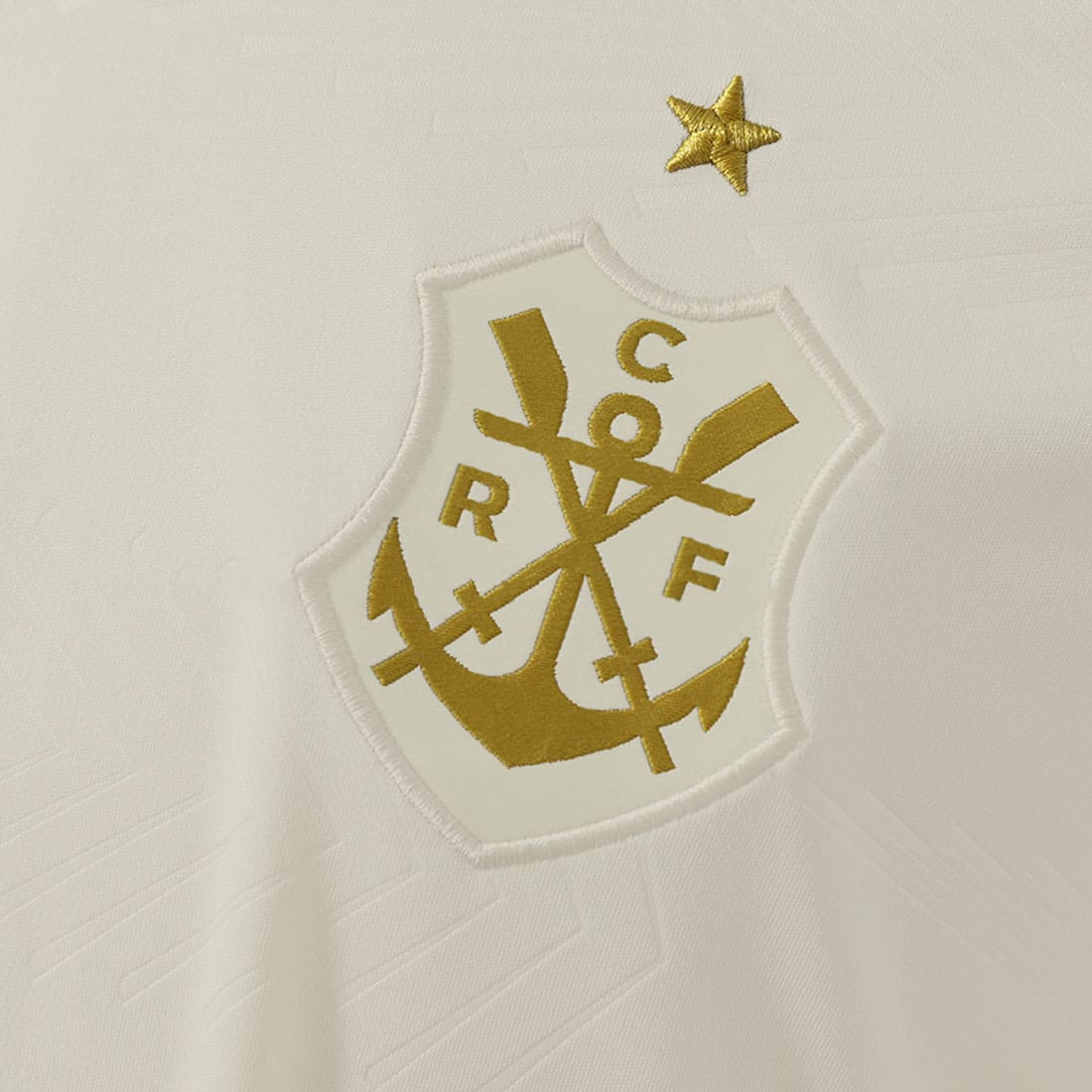 Detalhe do escudo retrô dourado da Camisa Flamengo III 25/26 Feminina