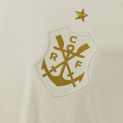 Detalhe do escudo retrô dourado da Camisa Flamengo III 25/26 Feminina